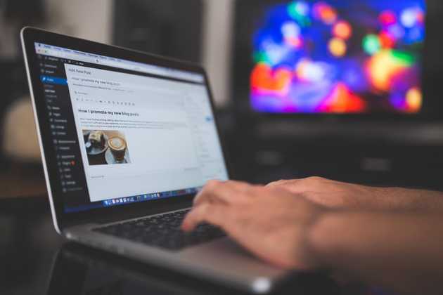 Hands typing a website on a macbook